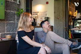 Two colleagues laughing during a coffee break