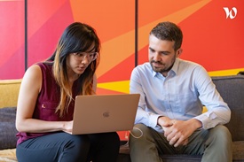 Two team members collaborating on a laptop